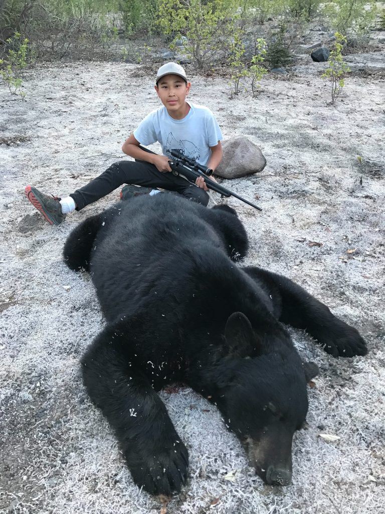 Hunter with bear during a baited bear hunt.